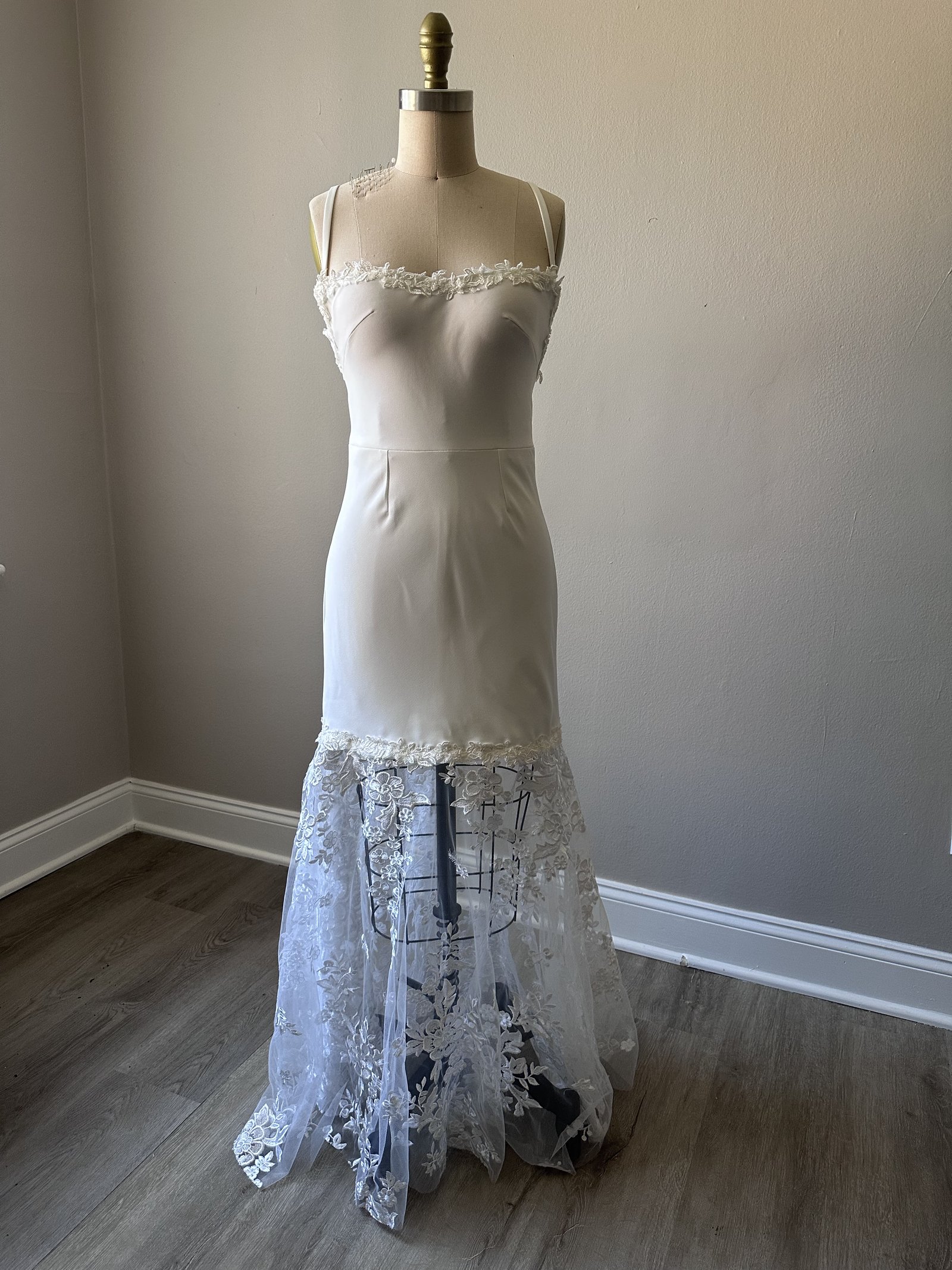 Ivory wedding gown with hand-applied floral lace skirt on dress form