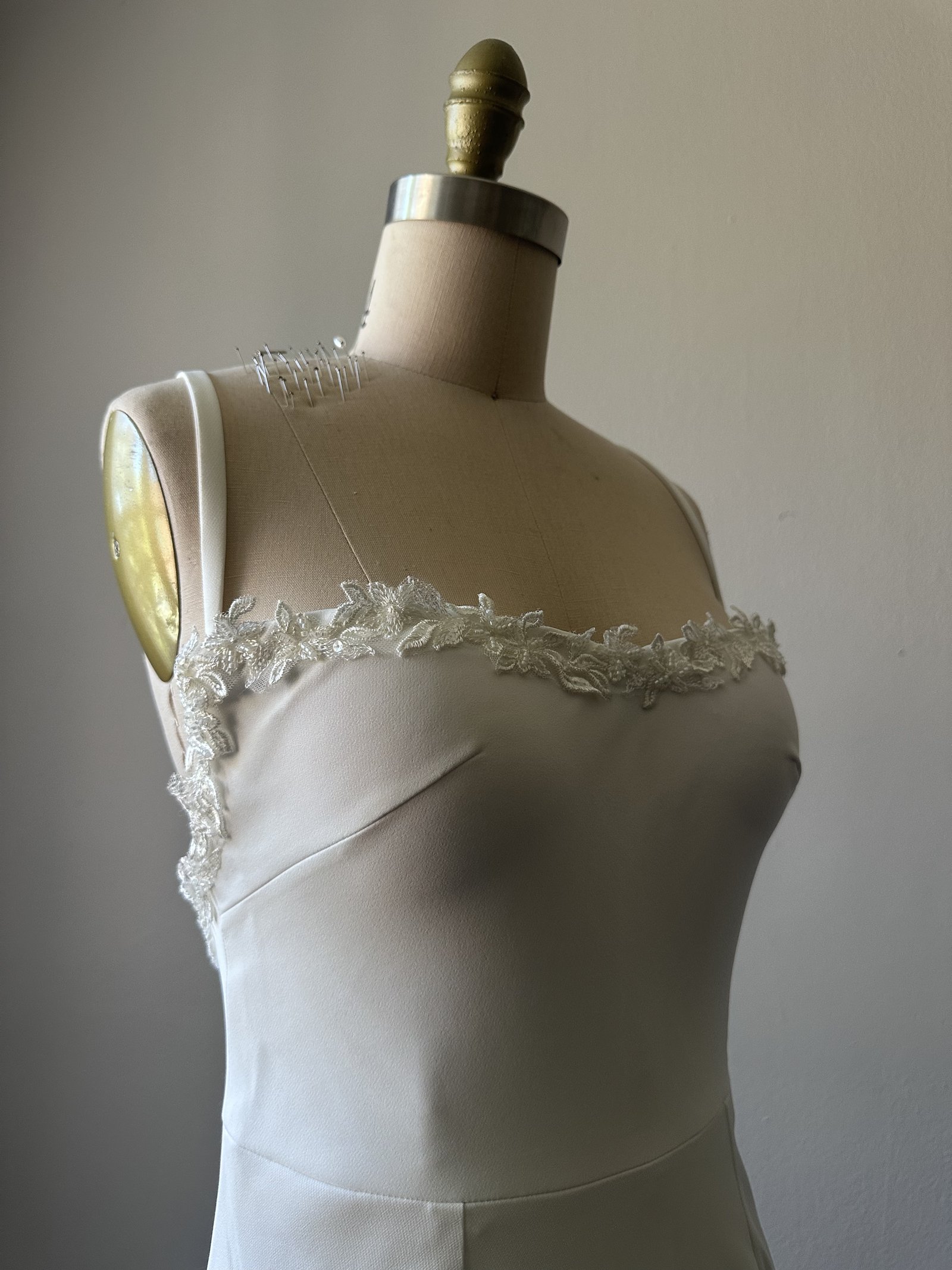 Hand-applied beaded lace along the neckline of a couture wedding gown